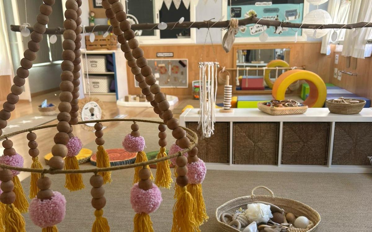 Aula de bebés (I0) con cesto de los tesoros y móvil de madera
